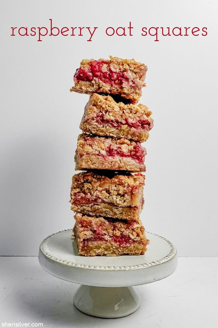 Raspberry oat squares stacked on a mini cake stand
