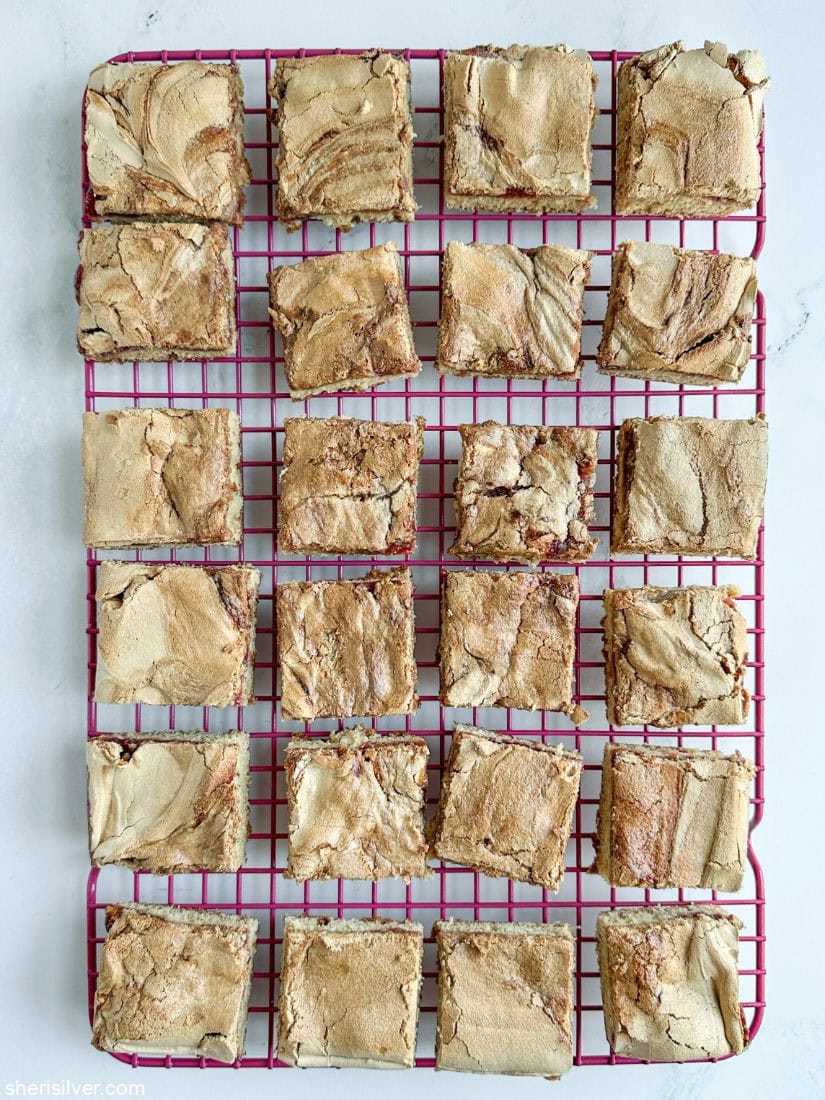 Cranberry curd mud hen bars on a pink cooling rack