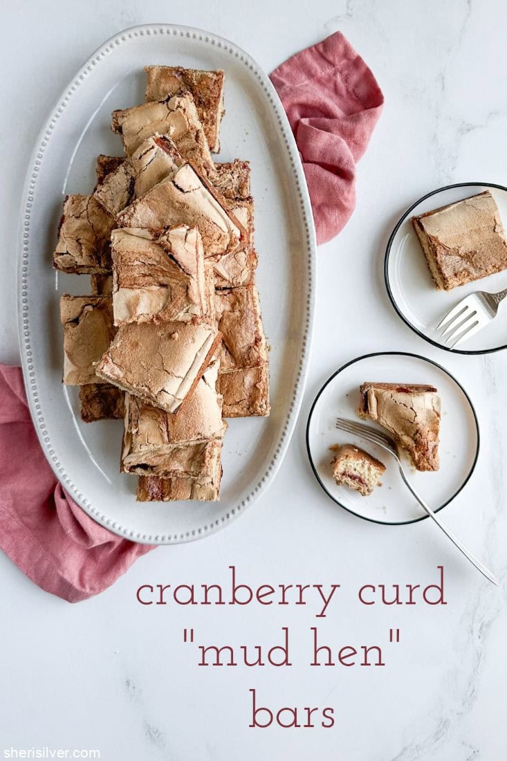 Cranberry curd mud hen bars on a white ceramic platter and white plates