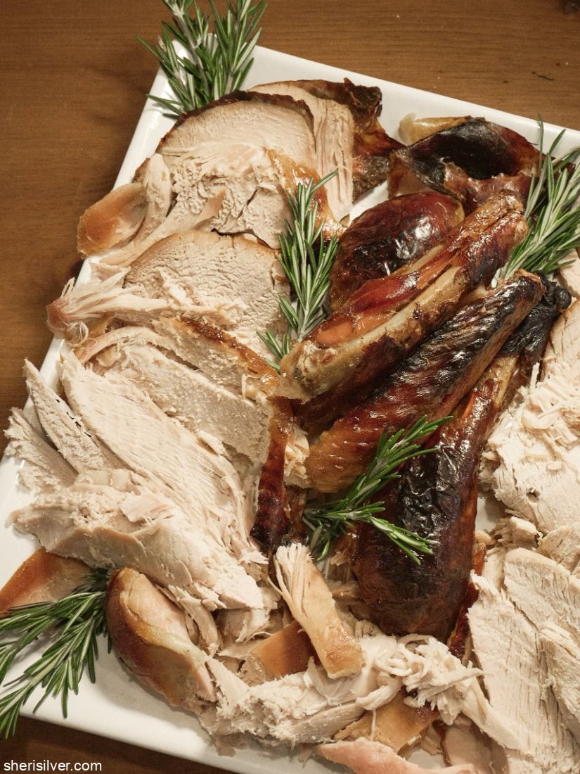 Thanksgiving turkey on a white platter with rosemary sprigs