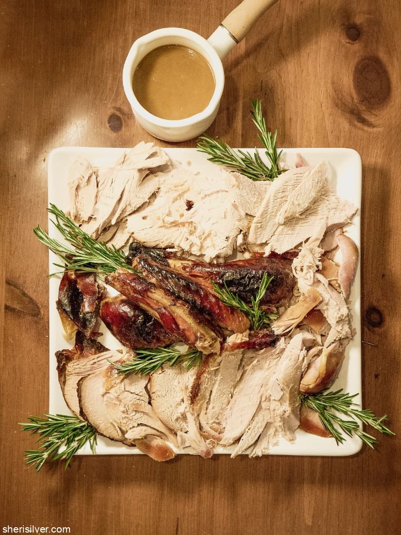 Thanksgiving turkey on a white platter with rosemary sprigs