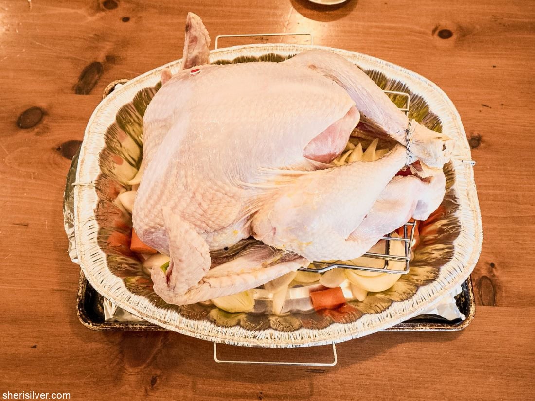 Thanksgiving turkey over vegetables in a roasting pan
