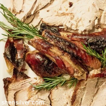 Thanksgiving turkey on a white platter with rosemary sprigs