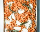 butternut squash on a baking sheet with onions and rosemary