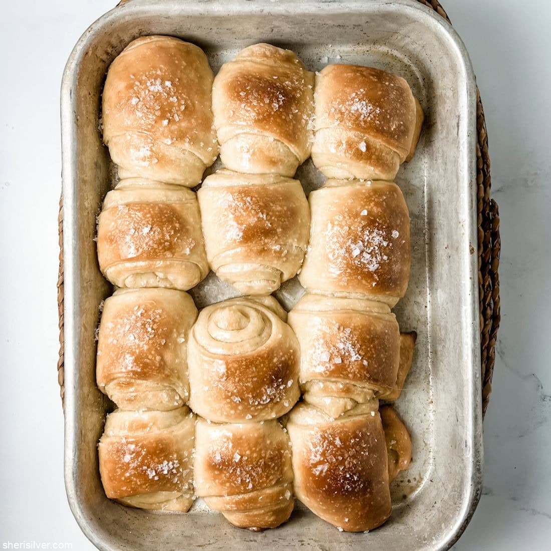 honey butter parker house rolls in a baking pan