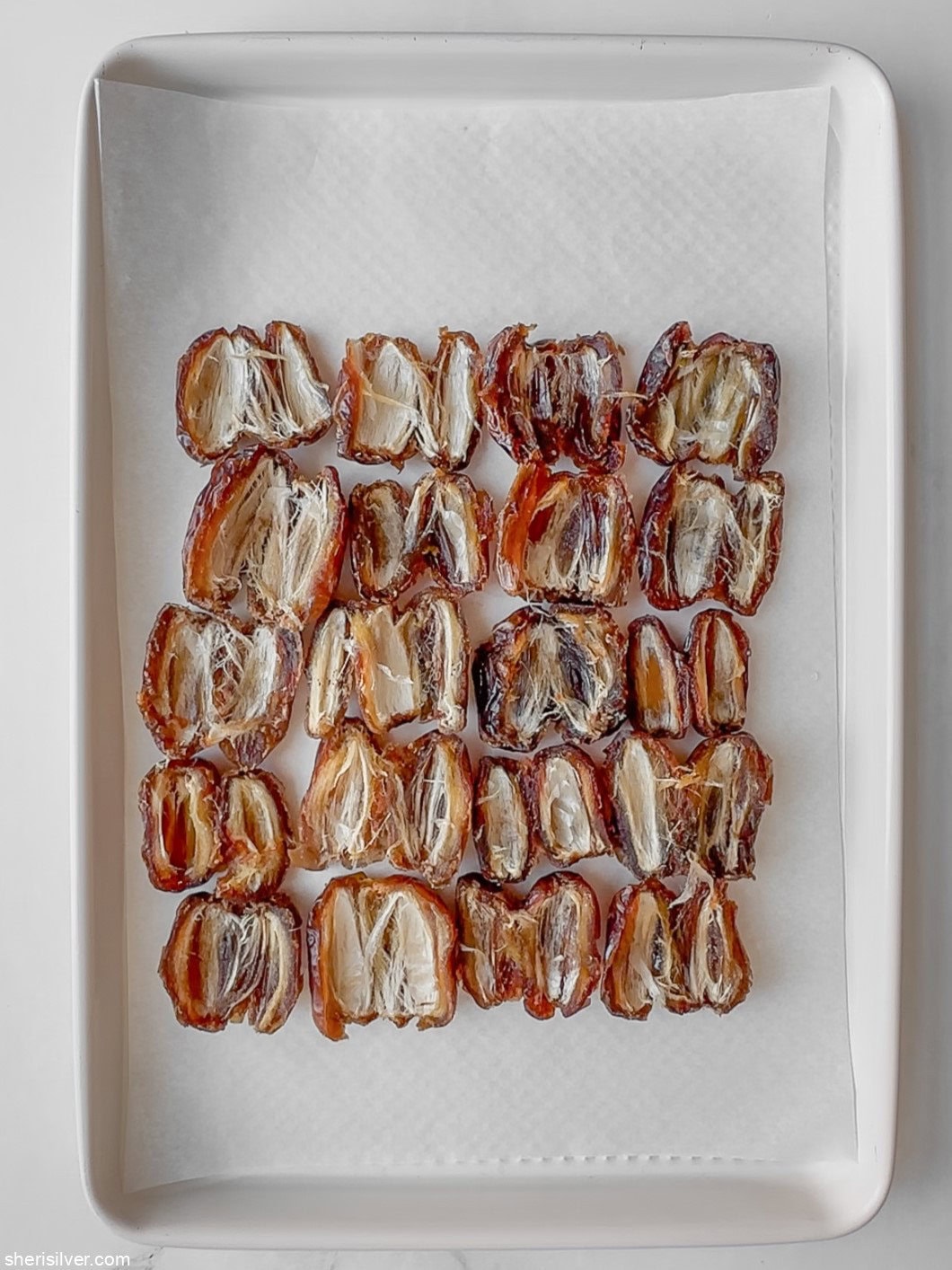 flattened dates on a baking sheet