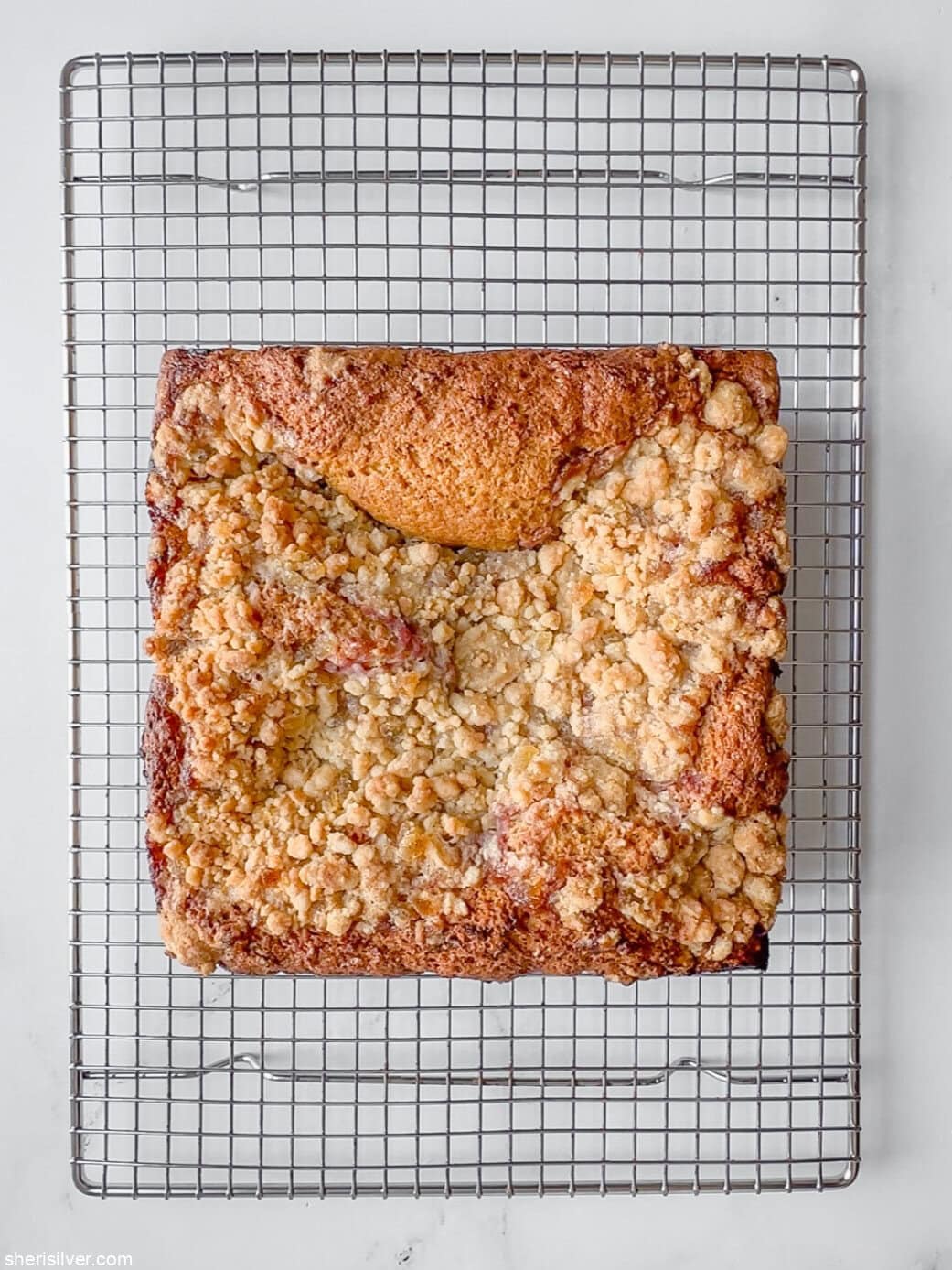 spiced coffee cake with raspberry curd on a wire cooling rack