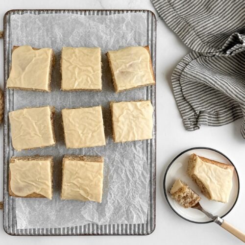 lemon ginger snacking cake with maple glaze on a ribbed metal board