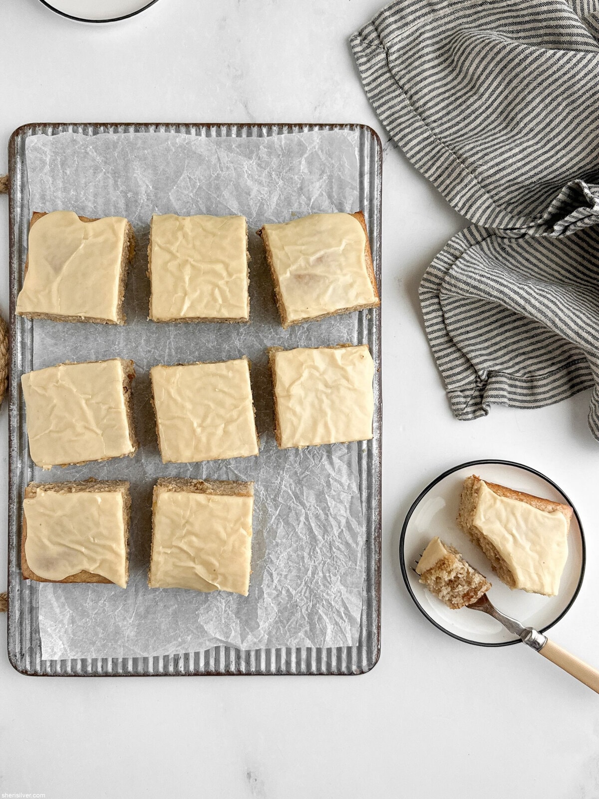 lemon ginger snacking cake with maple glaze on a ribbed metal board