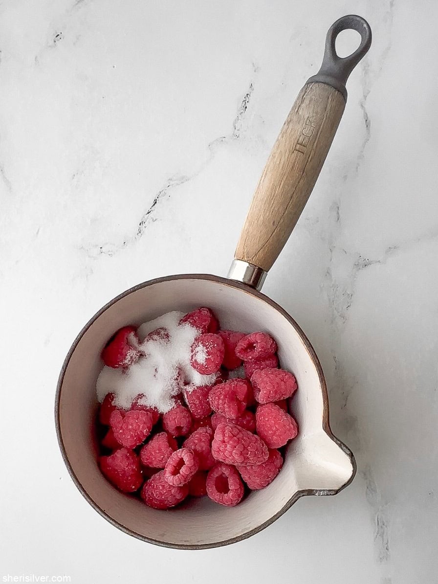 raspberries and sugar in a saucepan for red white and blue pavlova parfaits
