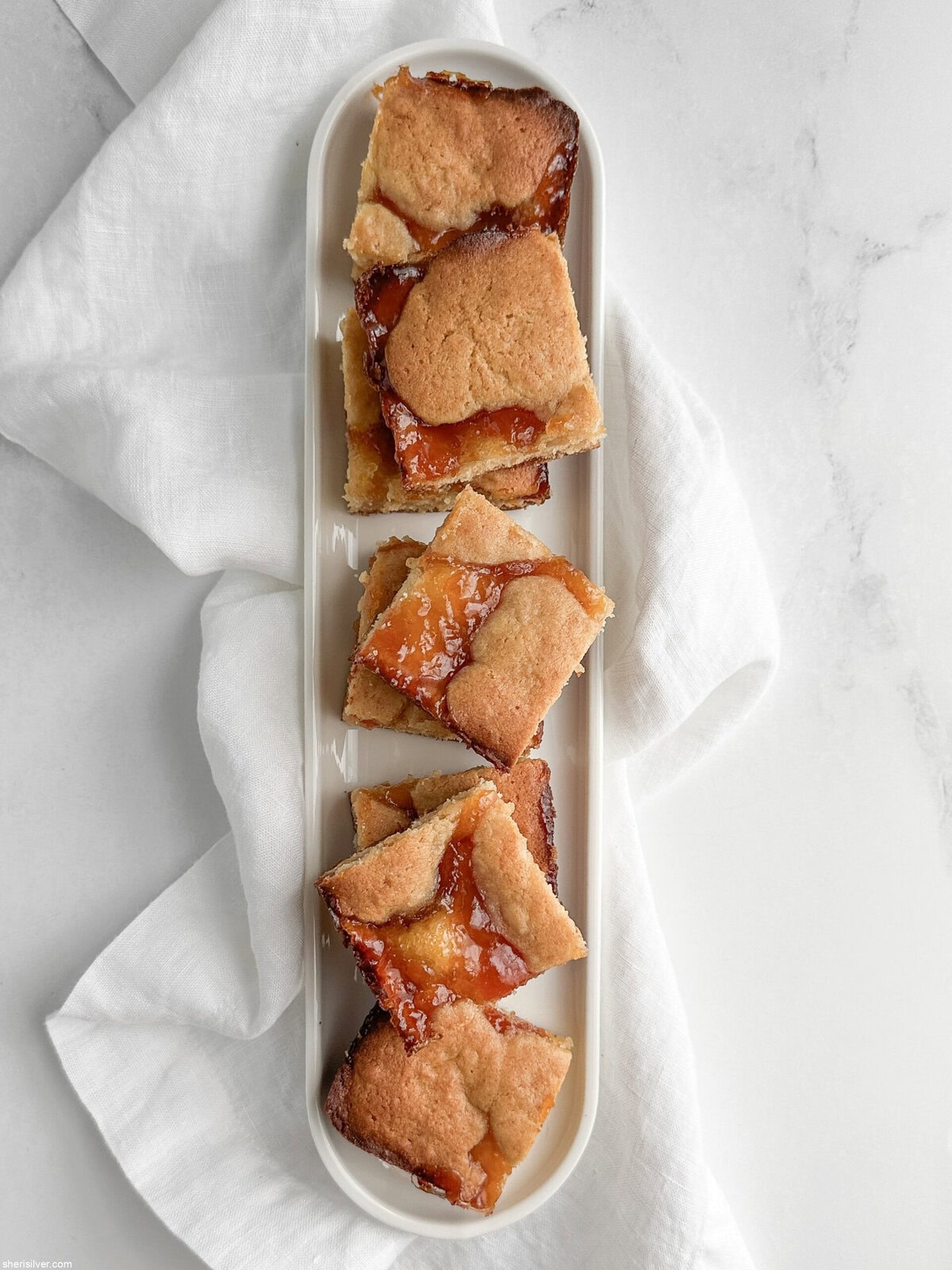 apricot almond bars on a white tray