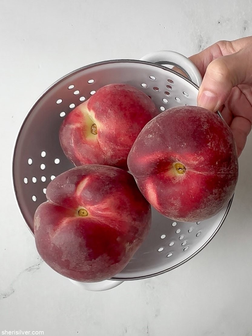 peaches for easy peach galette in a white colander