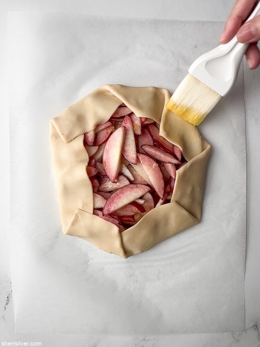 unbaked easy peach galette brushed with egg