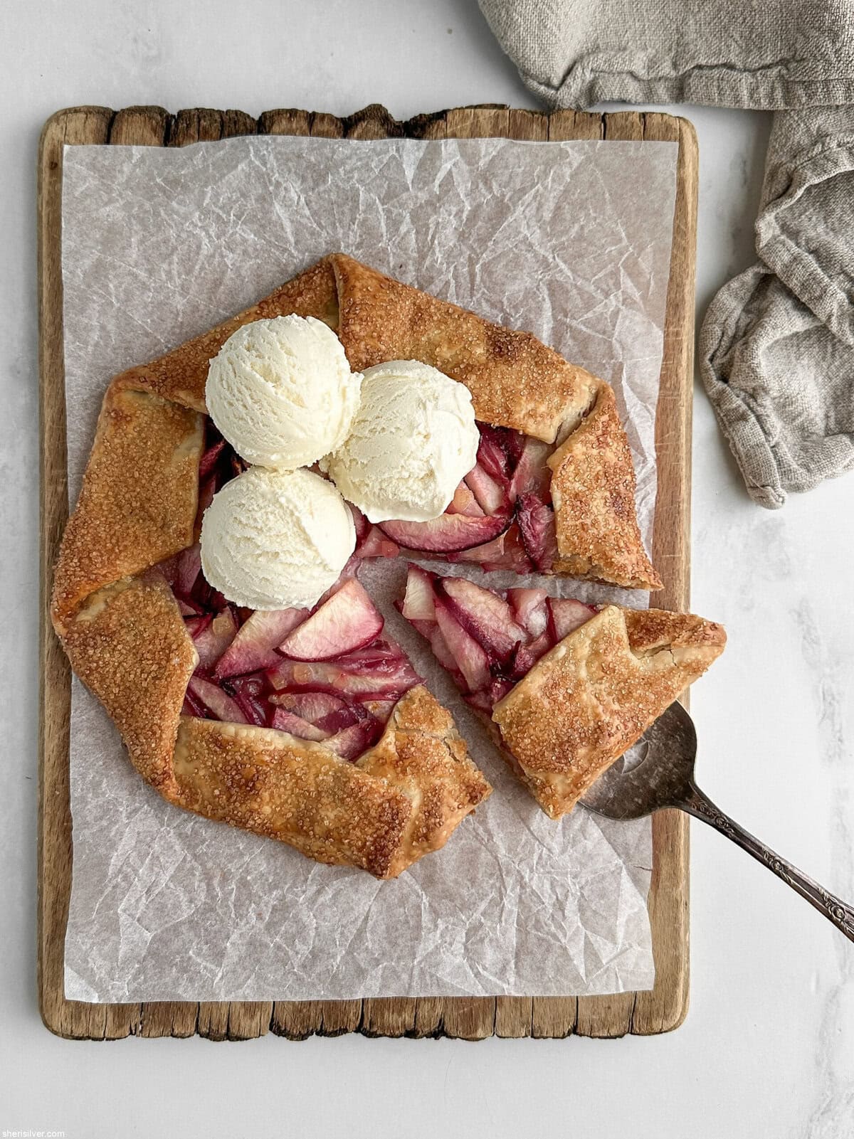 easy peach galette with vanilla ice cream on a wooden board