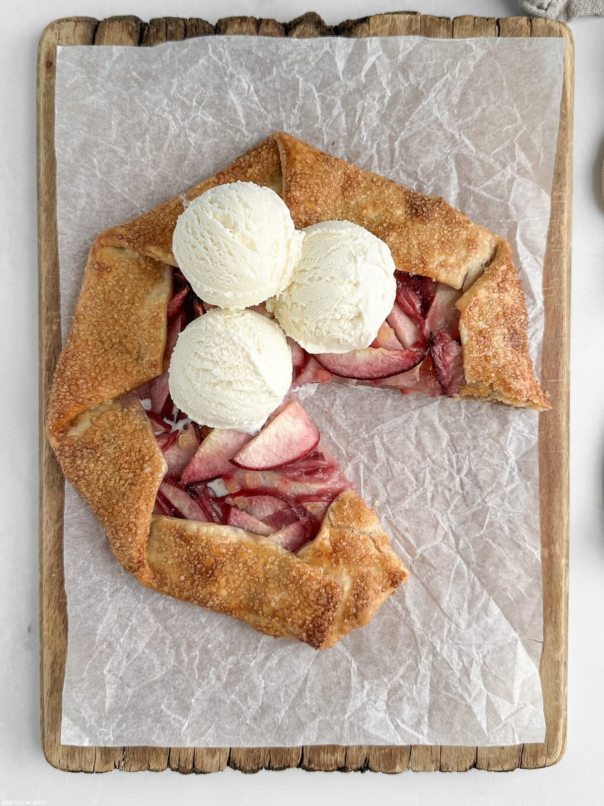 easy peach galette with vanilla ice cream on a wooden board