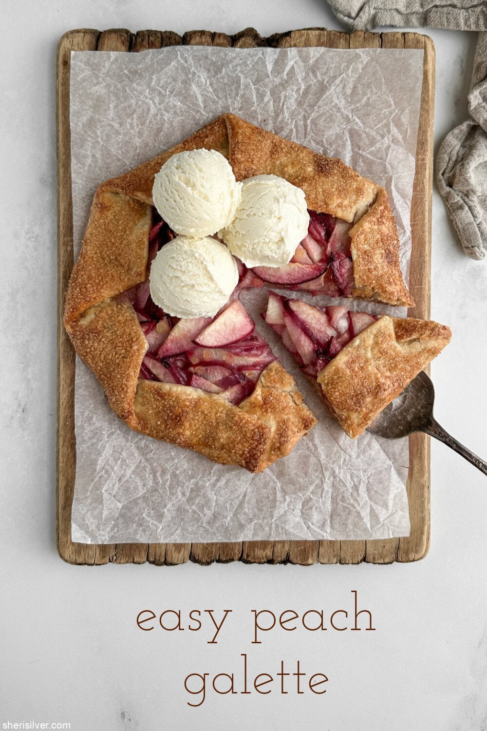 easy peach galette with vanilla ice cream on a wooden board