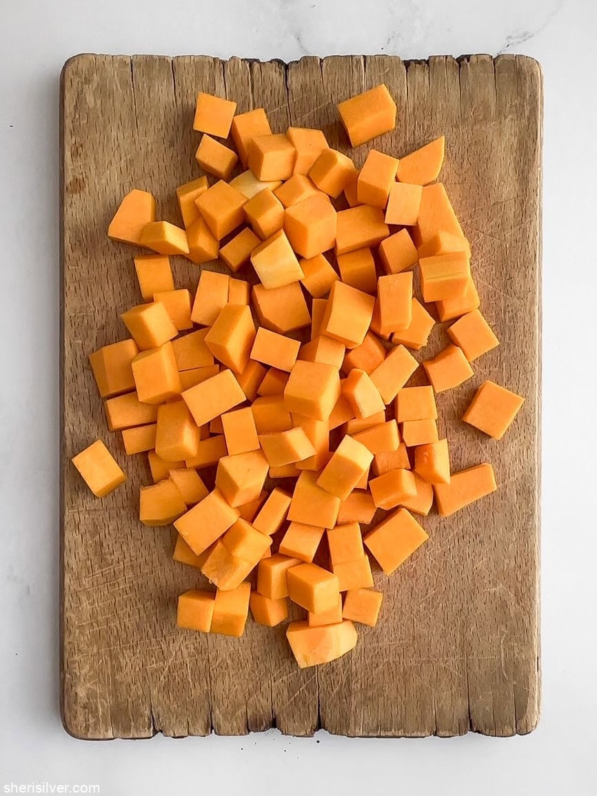 Peeled and cubed butternut squash on a cutting board for roasting