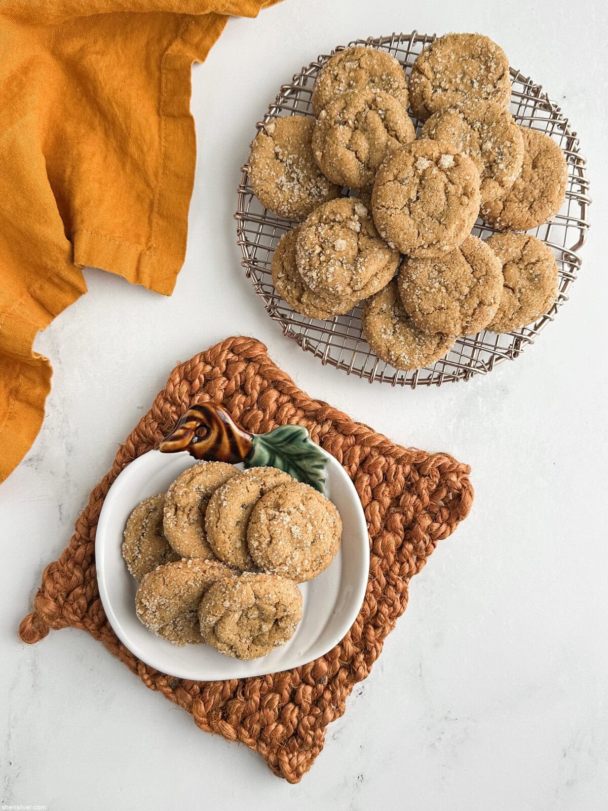 Chewy pumpkin cookies with candied ginger served on a rack and a pumpkin-shaped plate with fall table decor