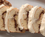 Overhead close-up of sliced cinnamon roll loaf cake on a white platter.