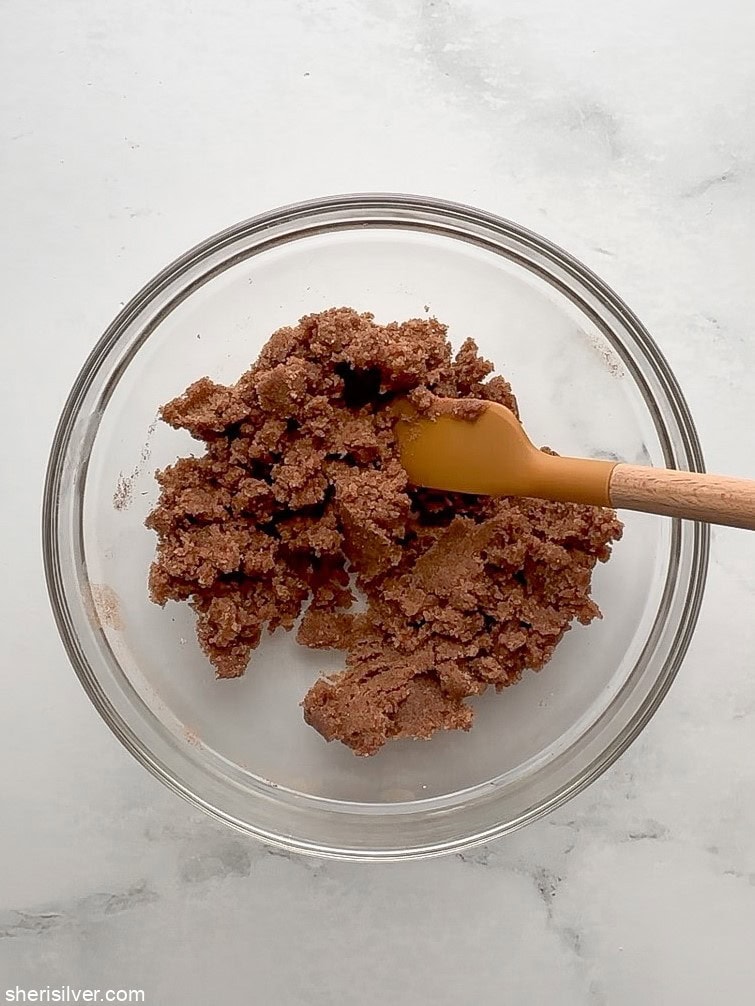 Brown sugar cinnamon filling mixture in a mixing bowl with spatula